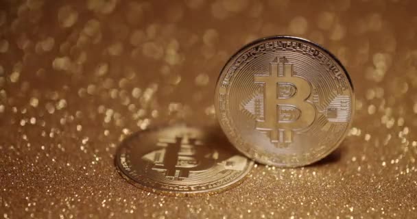 Close Up op gouden achtergrond met bokeh. Bitcoin BTC munt. Nieuwe virtuele valuta. — Stockvideo