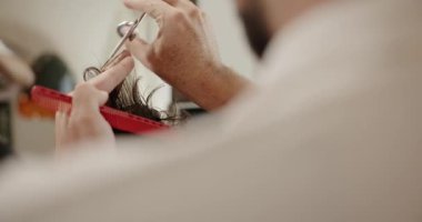 Makasla saç kesen bir erkek, yakın plan. Bir kuaförden hizmet alıyorum.