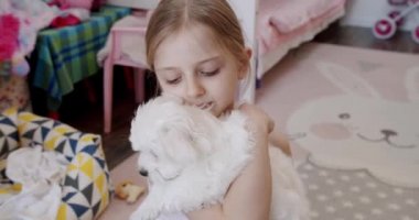 7 yaşındaki kız evde köpek yavrusuyla oynuyor. Çok mutlu..