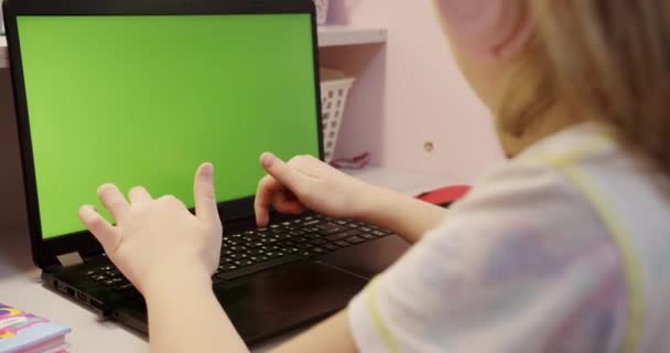 Дівчина-підліток навчається вдома на портативному комп'ютері з зеленим екраном вдома . — стокове відео
