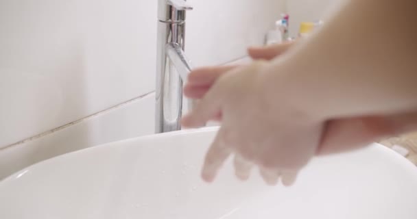Jonge vrouw wassen handen met zeep over wastafel in de badkamer, close-up. Coronavirus — Stockvideo