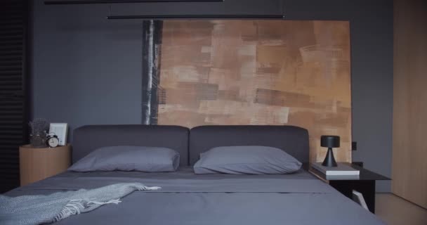 Η μοντέρνα μινιμαλιστική κρεβατοκάμαρα με μαύρο και γκρι τόνο, μεγάλα έργα ζωγραφικής και ξύλο — Αρχείο Βίντεο