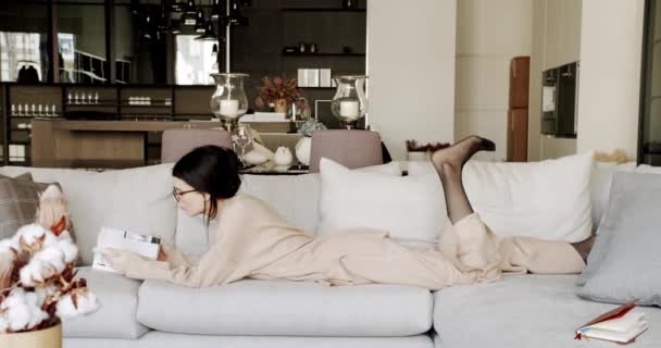 Friedliche Millennial Frau entspannt auf bequemen gemütlich ein Buch lesen — Stockvideo