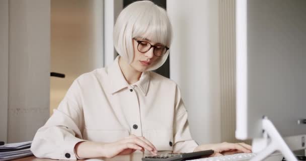 Kvinna sitta på arbetsplatsen skrivbord arbetar och med hjälp av miniräknare laptop, beräkna kostnader — Stockvideo