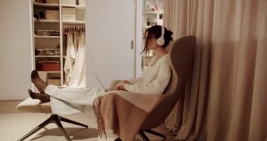 Güzel Genç Kadın Laptop Bilgisayarında kablosuz kulaklıklarla çalışıyor..