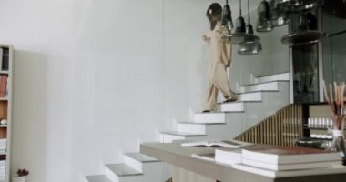 Merdivenlerden inen genç, bağımsız, beyaz bir kadının yavaş çekim fotoğrafı.