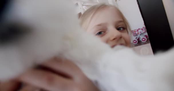 A 7 éves kislány otthon játszik a kiskutyájával, egészséges kutyatevékenységgel. — Stock videók