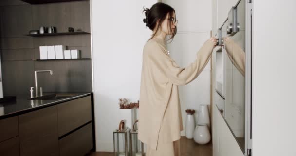 自宅でモダンなキッチンでコーヒーを作る美しい若い女性. — ストック動画