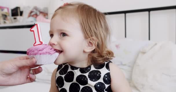 Een verjaardagsfeestje voor een schattig en gelukkig 1-jarig meisje en het eten van een kleine taart. — Stockvideo