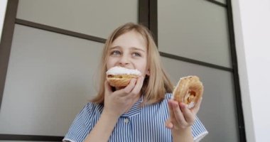 Genç bir kız doğum günü için evde lezzetli bir donut yiyor..