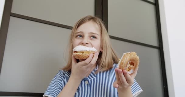 Een tienermeisje eet een heerlijke donuts thuis voor haar verjaardag. — Stockvideo