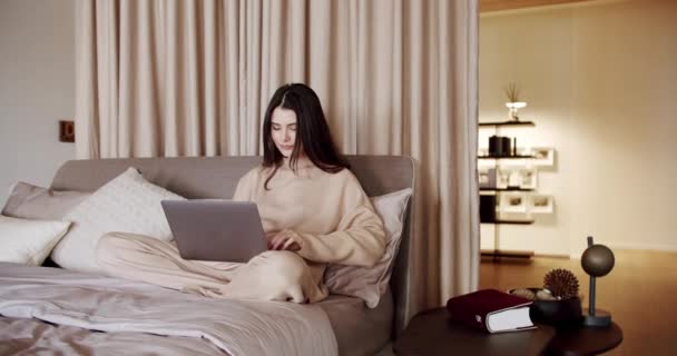 Zakelijke vrouw dragen headset video conferentie bellen op laptop computer op een bed — Stockvideo