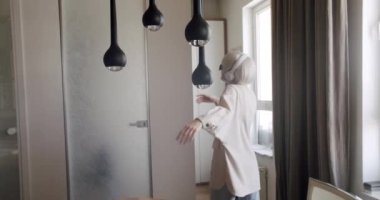 Beyaz saçlı neşeli bayan beyaz kablosuz kulaklıkla müzik dinliyor..
