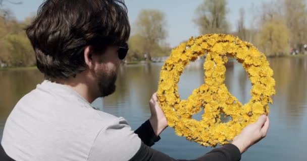 Een man heeft het vredessymbool op het blauwe water dat de vlag van Oekraïne vormt. — Stockvideo