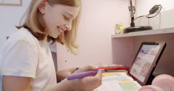 De tiener is thuis tekening aan tafel, de kinderkamer in roze kleuren — Stockvideo