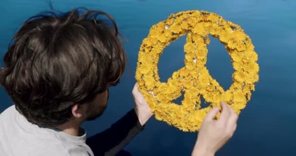 A man makes Peace sign from flowers. Concept of peace and support of Ukraine — Vídeo de Stock