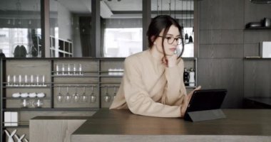 Modern mutfak odasında dijital tablet kullanan güzel bir kadın.
