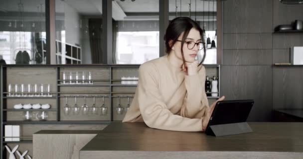 현대식 주방에서 디지탈 태블릿을 사용하는 집의 아름다운 여인 — 비디오