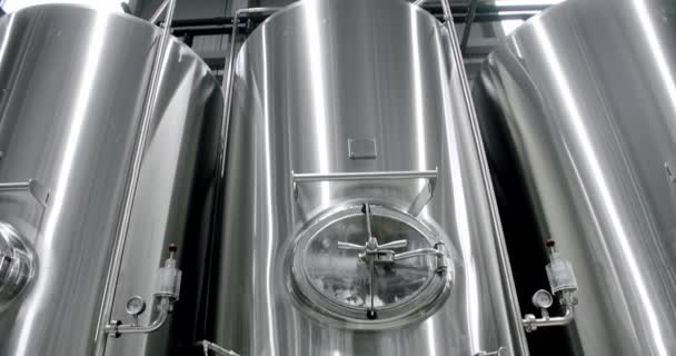 Az ipari sörfőzdében sörrel ellátott nagy acéltartályok sorainak burkolása. — Stock videók