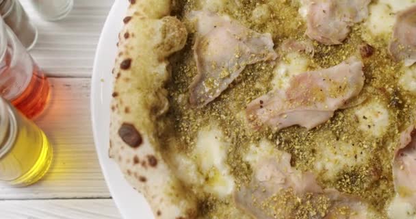 Pizza with Meat, Pesto, Cheese and Parmesan fresh out of the oven ready to eat. — Stock Video