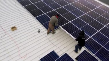 Güneş teknisyenleri evin çatısına güneş panelleri kuruyor. Teknisyen Çalışması.