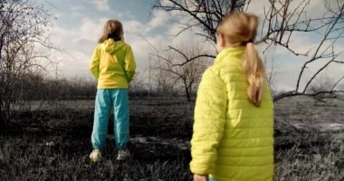 The younger sisters dressed in the colors of the Ukrainian flag embrace.