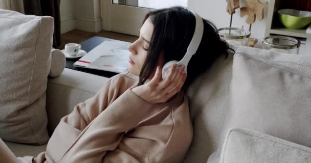 Mindful young happy woman wearing wireless headphones, listening relaxing music — Vídeos de Stock