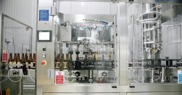 Beer bottles on automated machine during capping process.Factory,brewery concept — Stockvideo