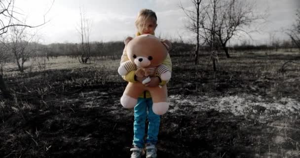 Ukrayna bayrağı renginde, Ukrayna savaşında oyuncak bir ayıyla yetim bir çocuk. — Stok video