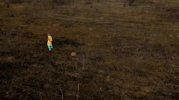 身穿乌克兰国旗颜色衣服的乌克兰女孩在地上被毁和烧毁 停止侵略 乌克兰民族色彩 可悲的难民儿童 — 图库视频影像