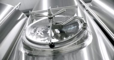 Stainless steel tanks for brewing beer. Huge stainless vats in a brewery. Equipment for beer fermentation. Brewing equipment. Factory, brewery concept. Modern brewery.