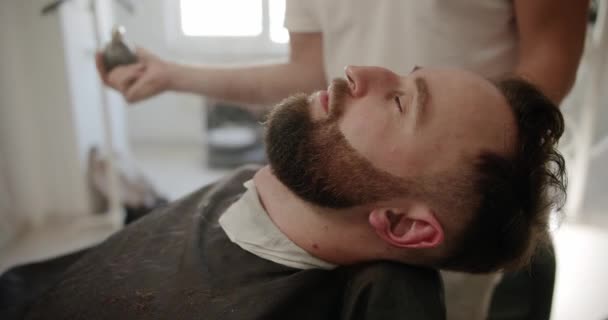 有魅力的男性正在理发店理发 理发师用喷雾把头发梳好 理发店 理发师在复古发廊理发 男人的发型 — 图库视频影像