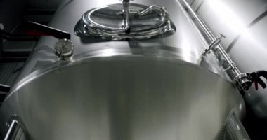 Stainless steel tanks for brewing beer. Huge stainless vats in a brewery. Equipment for beer fermentation. Brewing equipment. Factory, brewery concept. Modern brewery.