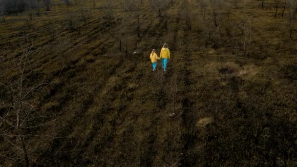 身穿乌克兰国旗颜色衣服的乌克兰女孩在地上被毁和烧毁 停止侵略 乌克兰民族色彩 可悲的难民儿童 — 图库视频影像