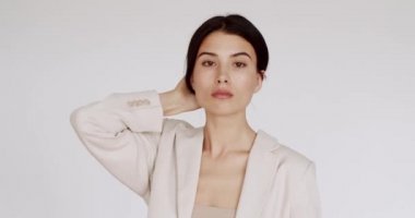Yüzü sağlıklı, temiz, yeni ciltli beyaz duvarda güzel bir bayan model. Mükemmel genç ten ve güzellik kavramı. Güzellik videosu konsepti, yakın plan portre. Şirin Moda Modeli.