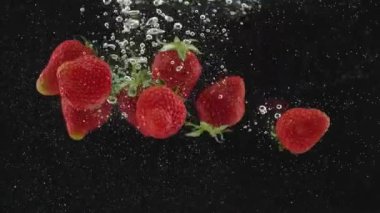Süper yavaş çekimde suya düşen taze çilek meyvesi. Suya düşen taze çilek. Beaty Strawberry suyun içinden geçiyor. Sağlıklı Doğal Vegan Gıda kavramı. Lezzetli Yaz Meyveleri.