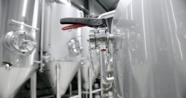 Huge stainless vats in a brewery. Equipment for beer fermentation. Brewing equipment. Factory, brewery concept. Large reservoirs, tanks and pipes with manometers in private microbrewery.