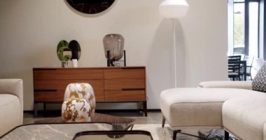 Modern masa, beyaz kumaş kanepe ve depolama mobilyalarıyla İskandinav iç mimarisi. Minimalist ve modern oturma odası. Yastıklı tekstil döşeme kanepesi. Modern koltukla iç içe..