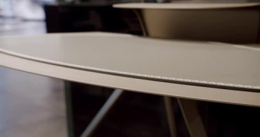 Modern çalışma masasını deri ve beyaz dikişli, rahat bir çalışma odasında ahşap kapatıyoruz. Modern Minimalist çalışma masası. Lüks mobilya ayrıntıları. İş yeri. Modern masadaki güzellik..