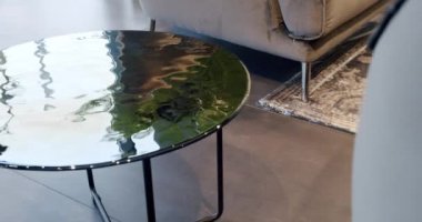 Oturma odasındaki cam modern yuvarlak masa. Modern Minimalist Yuvarlak Kahve Masası Çağdaş İçişleri 'nde oturma odasında. Ev lüks dekorasyonu. Çatı katı konforlu daire.