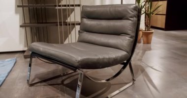 Oturma odasında modern gri deri koltuk. Gri koltuk tasarla. Modern apartman. Modern minimalist ev. Minimalist gri koltuk. Zarif ve rahat bir koltuk, sıcak ve rahat..