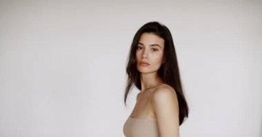 Moda modeli kameraya bakıyor. Kafkasyalı bir kızın çarpıcı yüzü. Güzel kahverengi gözlü seksi bir manken. Esmer, mutlu kadın güzellik portresi. Yaklaş. Cilt bakımı. Kozmetik ve makyaj.