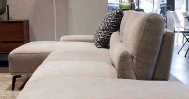 Modern gri ve bej kumaşlı kanepeyi kapatın. Yastıklı tekstil döşeme kanepesi. Modern apartman güzel bej kanepe minimalist oturma odasında. İskandinav iç mimarisi masa, depolama mobilyaları.