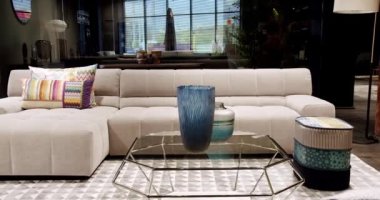 Modern masa, beyaz kumaş kanepe ve depolama mobilyalarıyla İskandinav iç mimarisi. Minimalist ve modern oturma odası. Yastıklı tekstil döşeme kanepesi. Modern koltukla iç içe..