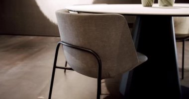 Kumaşı kapat ve yuvarlak yemek masalı modern kahverengi koltuğu kapat. Modern Minimalist Evi. Zarif ve rahat bir ev, sıcak bir ortam. Modern bej koltuk. İç Güvenlik Bölümü. Modern sandalye, masa.