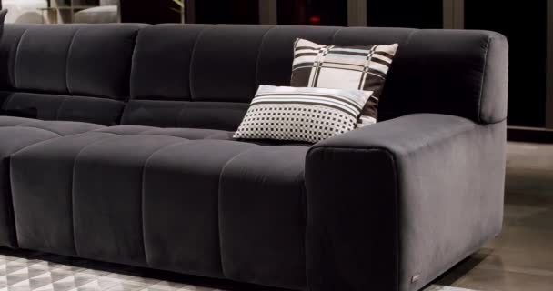 现代深灰色面料沙发 有枕头的纺织品软垫沙发 现代公寓漂亮的深灰色面料沙发在简约的客厅与餐桌 简约房中的灰色现代索法 — 图库视频影像