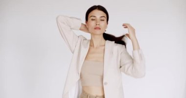 Yüzü sağlıklı, temiz, yeni ciltli beyaz duvarda güzel bir bayan model. Mükemmel genç ten ve güzellik kavramı. Güzellik videosu konsepti, yakın plan portre. Şirin Moda Modeli.