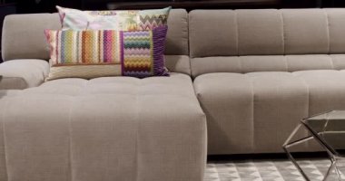 Modern gri ve bej kumaş kanepe. Yastıklı tekstil döşeme kanepesi. Modern apartman güzel bej kanepe minimalist oturma odasında lamba, masa. Gri modern kanepe minimalist odada.