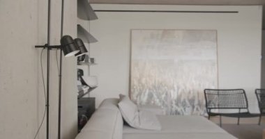 Oturma odası. Lüks minimalist tasarım, beyaz ve gri tonlu gerçek daire, zarif sandalye, lüks mobilya, projektör, duvarda televizyon ve siyah ses teknikleri, beton, minimalist tasarım.