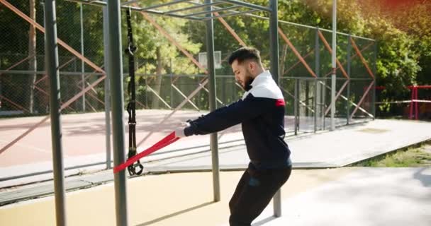 户外运动者用弹性带进行锻炼 有魅力的健身者在外面锻炼 健身的概念外 训练男子矫正适合用橡皮筋做体操 — 图库视频影像